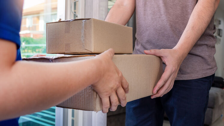 成人快递员托运或持纸板包裹送货货物帽子交货