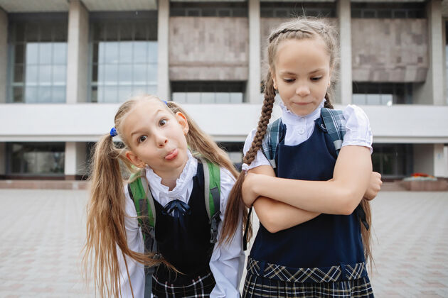 高尔夫两个穿着制服 梳着马尾辫的十几岁的女学生在镜头前摆姿势 做鬼脸裙子朋友小学生