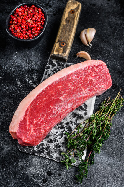生的盖臀牛肉牛排放在木制的切肉刀上桌面查看木头里脊长条