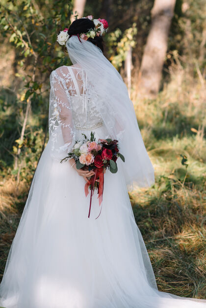 仪式新娘身穿白色婚纱 手拿花束优雅礼服玫瑰