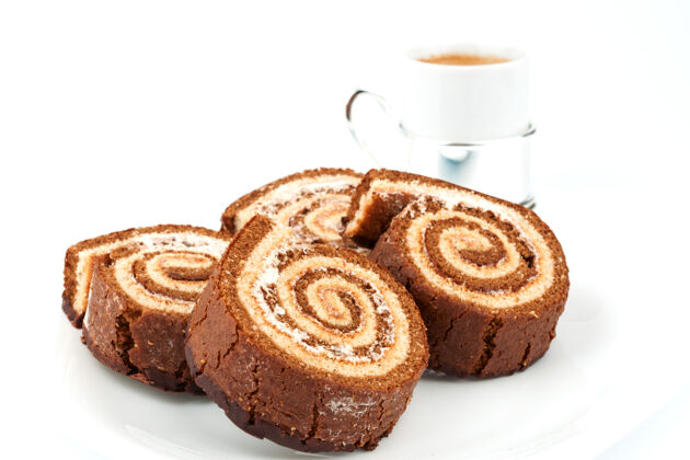 瑞士几个巧克力卷放在一个盘子里和一杯咖啡早餐卷咖啡