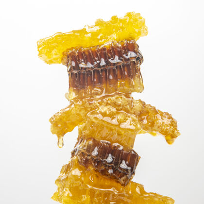 素食部分新鲜蜂巢上的白色背景.维生素天然的食物.蜜蜂工作成果打蜡蜂巢葡萄糖