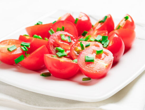 盘子用绿色装饰的樱桃西红柿洋葱一个白色的方盘子封闭料理饭