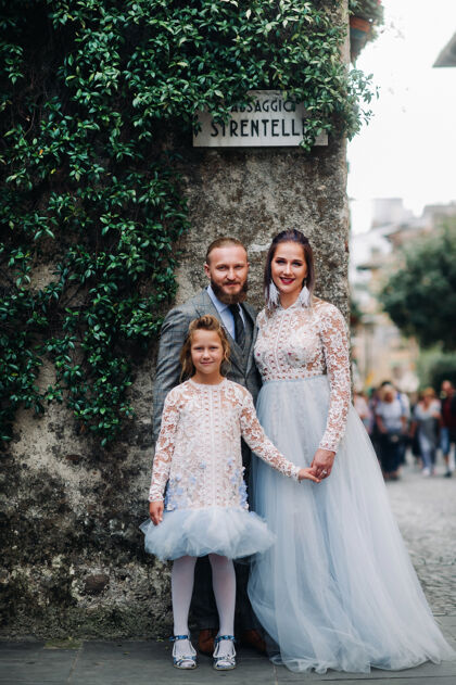 搜索一个幸福的年轻家庭走过锡尔米翁古城意大利时尚一家人在意大利散步著名意大利女儿