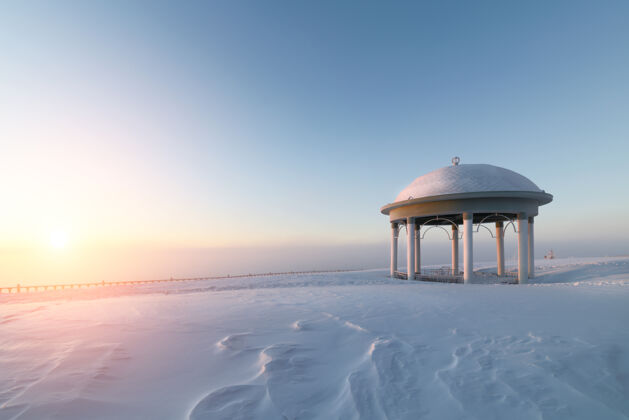 自然雪地上的圆形大厅平原冬天黎明冰冻白霜北极