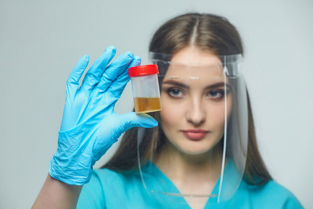 女性女医生手里拿着一瓶尿检设备女性专业