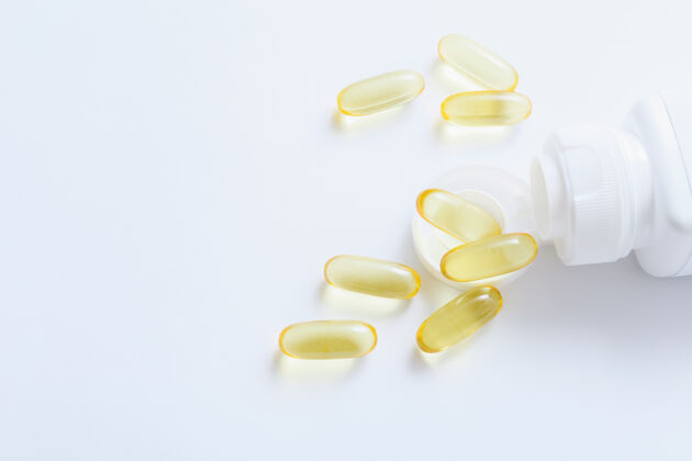 药丸鱼油维生素胶囊溢出药瓶上的白色药片健康药物健康