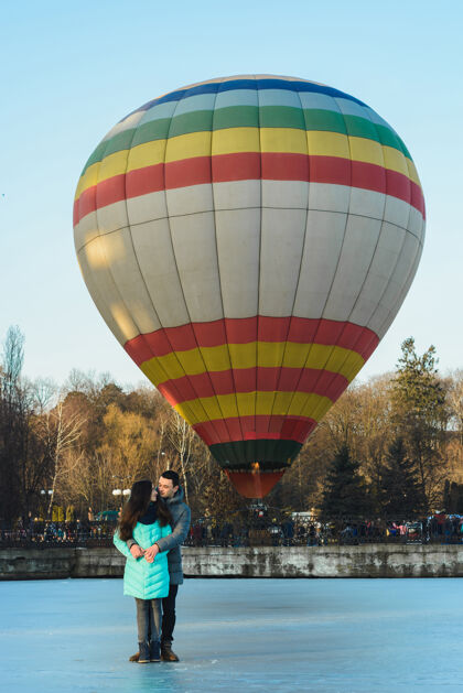 烟囱新娘和新郎在冰冻的湖面和城市公园里飞行的气球的背景下场景历史女性