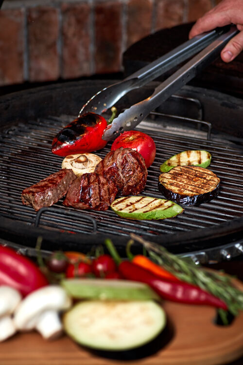 户外蔬菜和肉在烤架上发出咝咝声木炭迷迭香烹饪