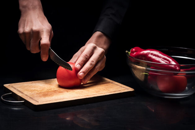 食物为了一个盘子关闭在餐厅里 年轻的厨师们一边切西红柿一边做饭 一边准备蔬菜做沙拉美味手工制作桌子
