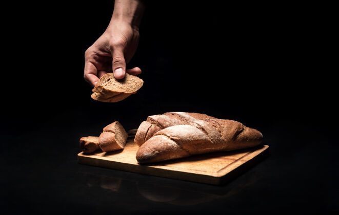 年轻柔软嘎吱嘎吱的在餐馆里做饭和准备菜的时候 男人的手拿着法式面包厨房产品对比
