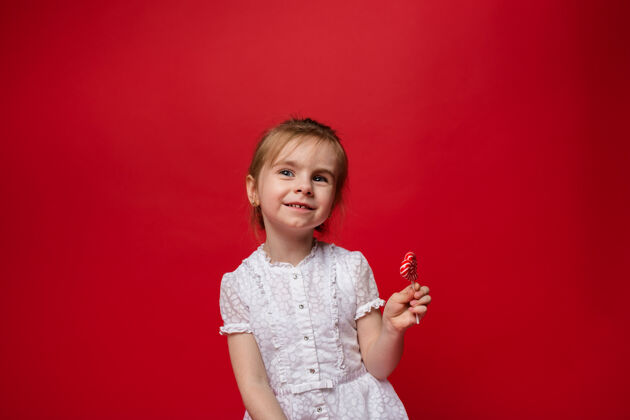 糖果一个小女孩的肖像 穿着白色的裙子 红色的是棒棒糖漂亮棒棒糖流行音乐