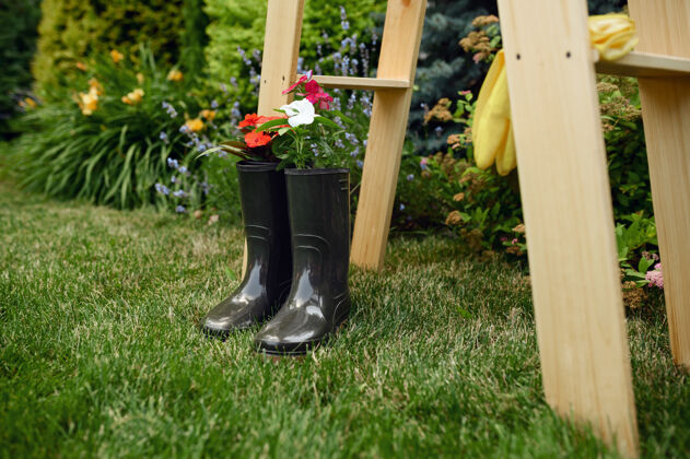 花盆园艺工具 木楼梯上穿着橡胶靴的花朵 没人园丁或花店设备 夏季爱好 花园特写铲子夏天