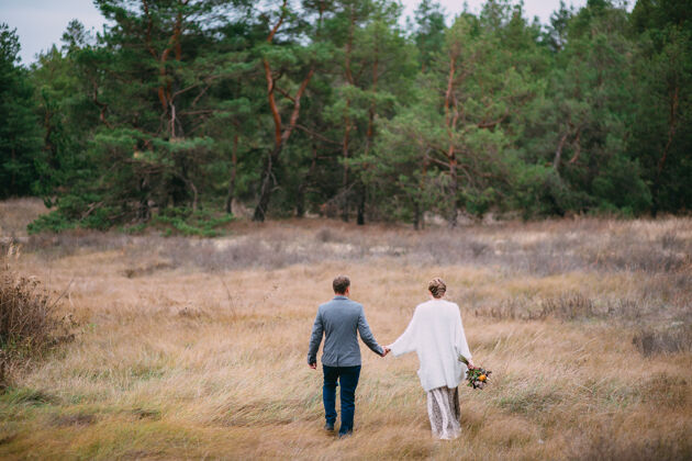风景一个男人在森林背景上牵着一个女人的手温柔女人散步