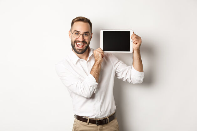 帅哥购物和科技帅哥男子展示数码平板电脑屏幕 戴眼镜配白领衬衫 工作室背景FormalShoppingTechnology