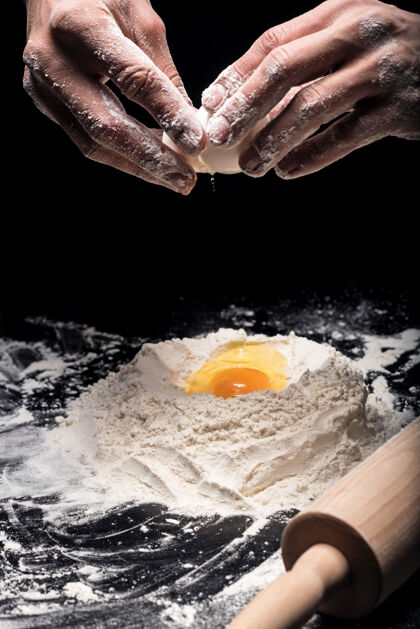 烘焙新鲜的面包店关门年轻人在做面团和当厨师的时候用鸡蛋面粉别针面包