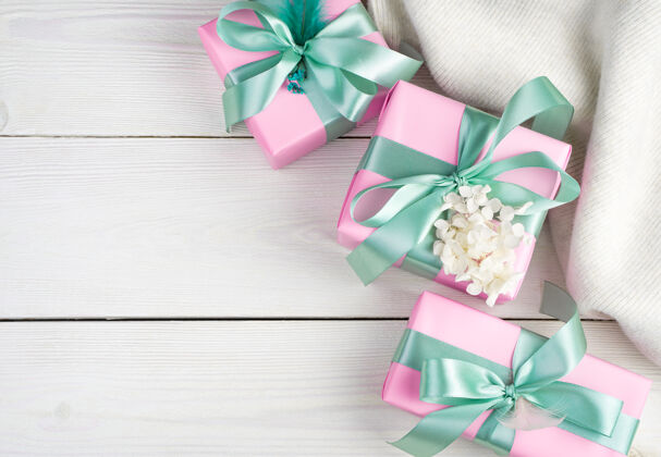 丝带柔软浪漫的背景与礼品盒和白色毛衣上的一个轻木背景.top查看周年纪念鲜花毛衣