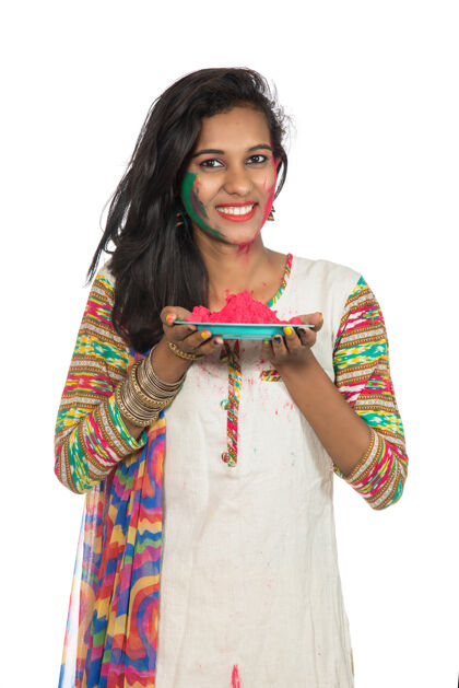 肖像在胡里节之际 美丽的年轻女孩拿着盘子里的彩粉庆祝女人粉