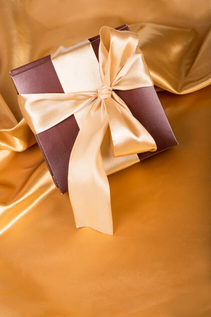 黑色甜蜜的惊喜 漂亮的礼物-棕色糖果盒和金色胶带黑色黄金康乃馨