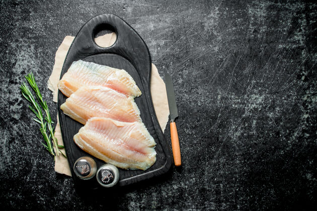 海鲜用刀 香料和迷迭香把鱼片放在砧板上块美食新鲜