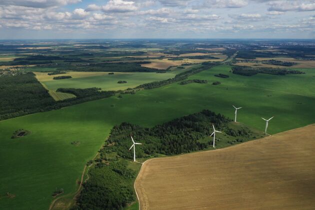 美丽风车在夏天的绿色字段大风车站在森林附近的田野里资源风电场草地