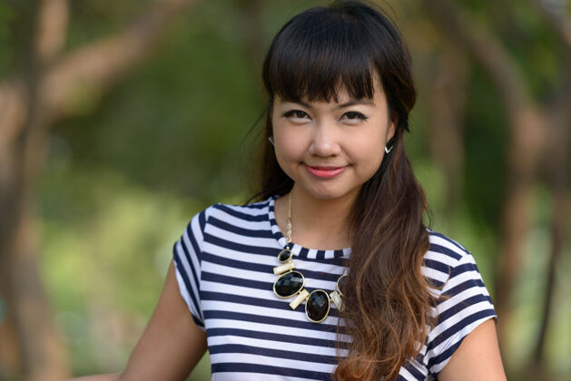 休闲年轻美丽的亚洲女子在公园户外放松的写真东南泰国邦