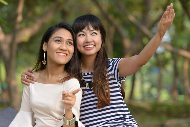 朋友两位亚洲年轻女性在公园户外放松的写真女性东南浪漫