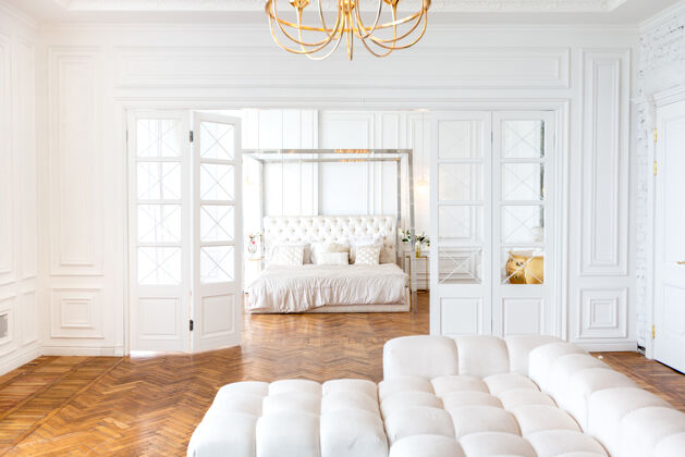 室内设计豪华宽敞明亮的两居室的现代室内公寓白色墙壁 豪华昂贵的家具 拼花地板和白色内门床漂亮房子