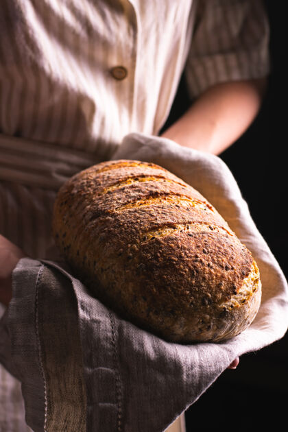 糕点拿着一条刚烤好的面包的女人健康面粉小麦