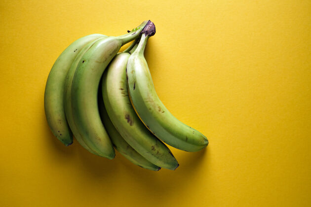 水果黄色背景上的绿色香蕉串健康无人一串