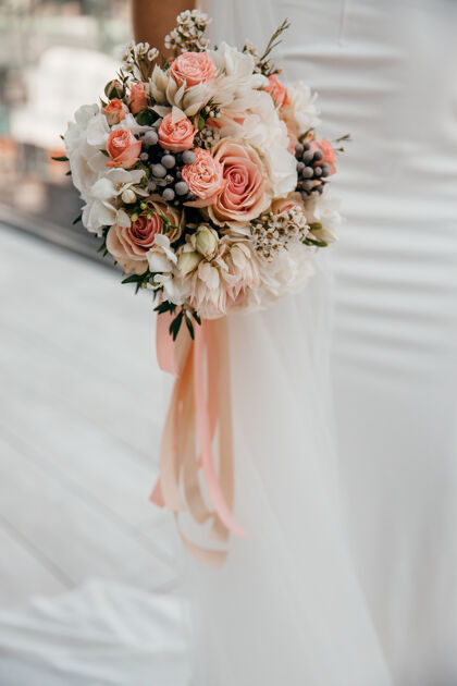 新娘优雅的婚礼花束在新娘手中一片白色手浪漫组成
