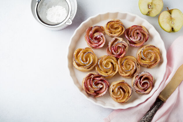 圆形美味的馅饼与一个苹果玫瑰在一个轻混凝土或石头表面陶瓷形式烘焙视图蛋糕