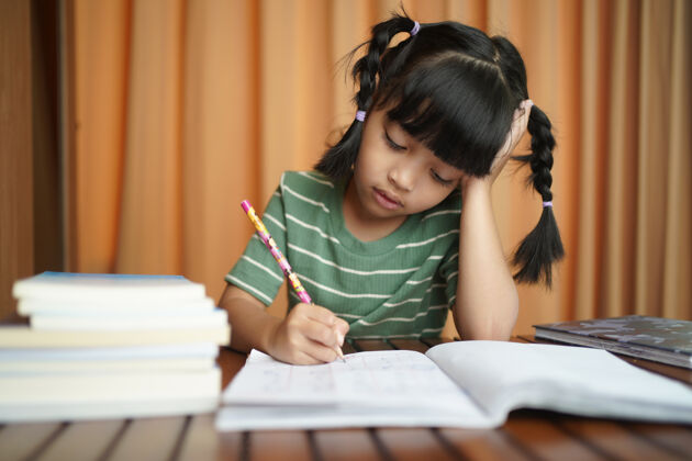 专注亚洲学生小女孩在纸上写字笔迹亚洲人写作