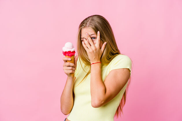 甜点一个年轻的俄罗斯女人吃着冰激凌 吓得手指直眨 紧张不安表情女孩恐慌