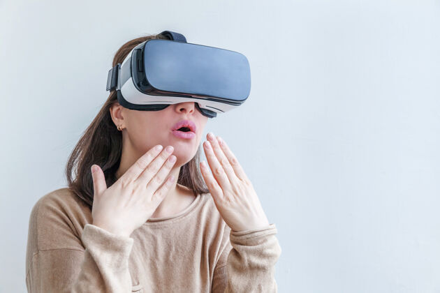 虚拟微笑的年轻女子戴着虚拟现实vr眼镜头盔耳机在白色背景上游戏未来视觉