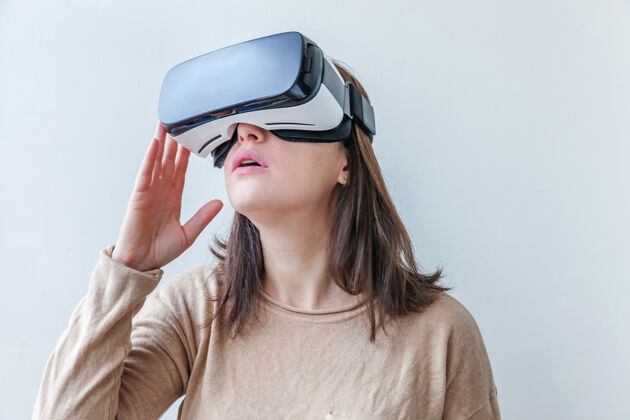 玻璃微笑的年轻女子戴着虚拟现实vr眼镜头盔耳机在白色背景上现实显示视觉