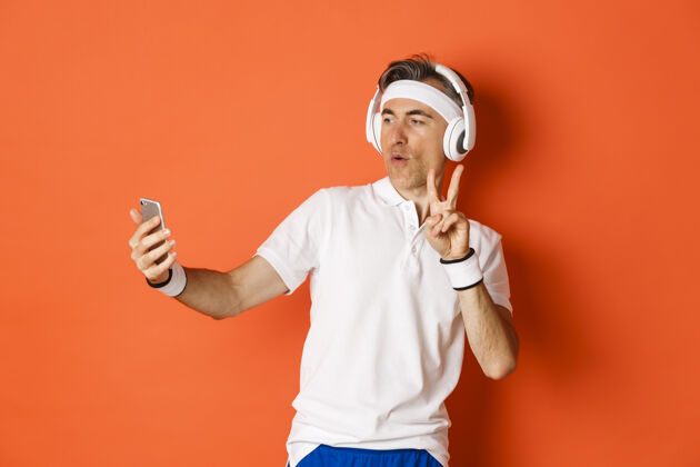 私人教练迷人的中年男运动员的肖像 在锻炼训练中自拍复制空间耳机英俊