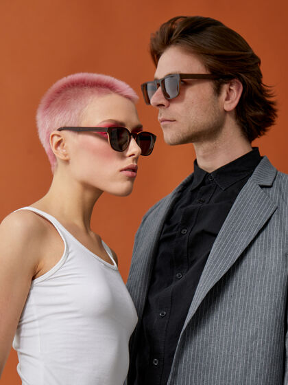 发型一对戴着太阳镜的时髦年轻时髦夫妇的侧面肖像 摆出彼此的姿势时髦成人女孩