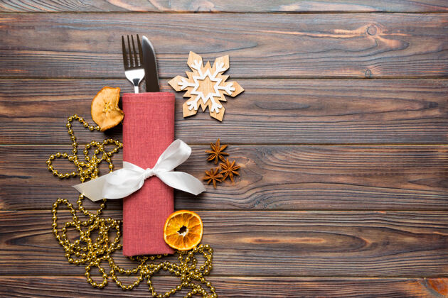 桌子木制背景上节日餐巾上餐具的俯视图冬天丝带圣诞节