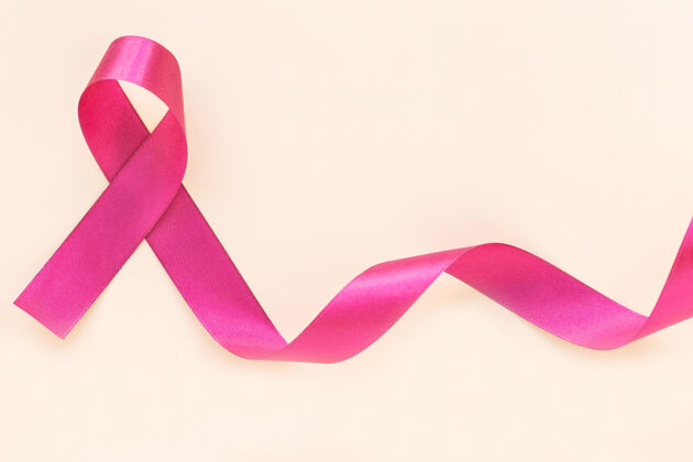 健康红紫红色丝带蝴蝶结卷曲在孤立的粉彩米色墙壁与复制空间 多发性骨髓瘤或浆细胞癌的象征意识癌症医疗医院
