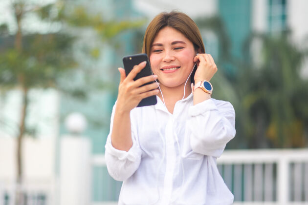 亚洲人亚洲女人用智能手机听音乐亚洲女人美丽电话