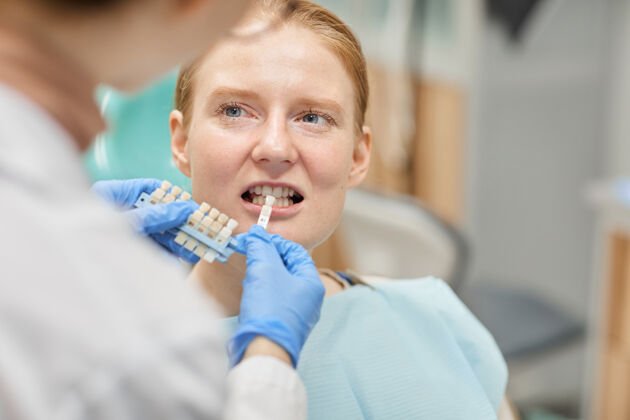 牙医牙医为她选牙冠时 病人露出牙齿成人诊所牙医办公室