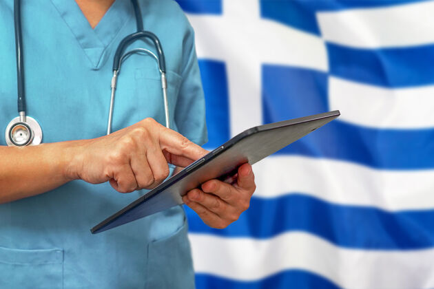 检查外科医生或医生使用希腊国旗背景上的数字平板电脑医院诊断工作