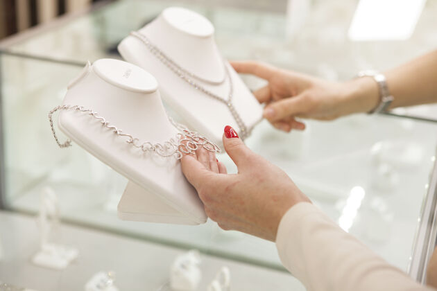 新娘无法辨认的女人在珠宝店挑选钻石项链新娘购买消费主义