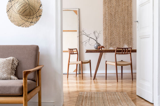 里面现代餐厅的时尚米色内饰 灰色沙发 设计木质橡木桌椅 花瓶和鲜花 优雅的藤条配件和装饰韩国风格的家居装饰棕色室内设计墙