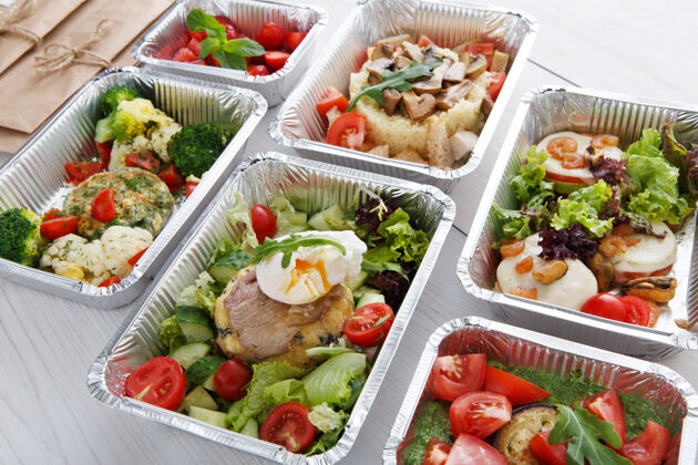 自然健康食品餐厅送货概念外卖餐铝箔盒午餐白木水煮鸡蛋配牛排和其他菜肴盒子美味肉