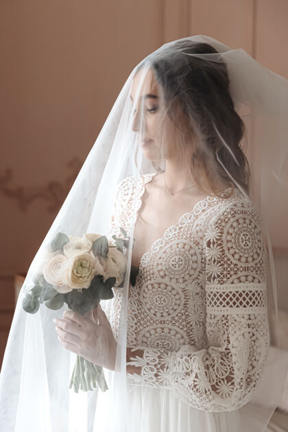 新娘年轻的新娘在一个美丽的波西米亚蕾丝礼服下长面纱优雅婚礼波西米亚