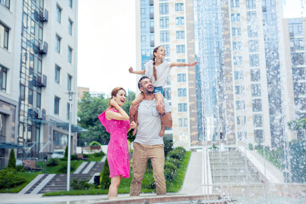 人际关系如此美丽快乐的一家人站在一起看着美丽的喷泉公寓乐观休息日