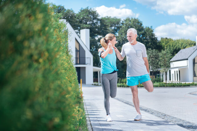 感觉慢跑后的伸展运动快乐的成年夫妇一起在家附近慢跑后的伸展运动让他们感到惊奇灵活休闲免疫力