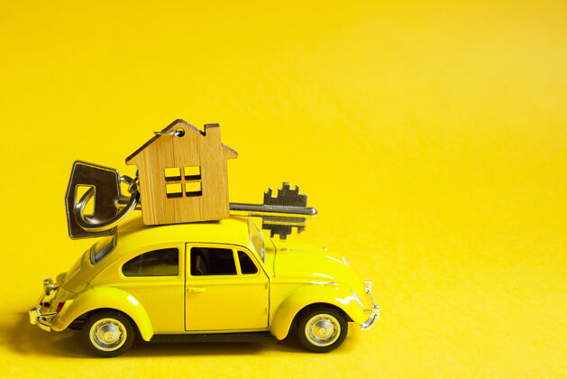 复制空间黄色的玩具车 屋顶上有一把房子的钥匙 背景是彩色的微型物业搬家